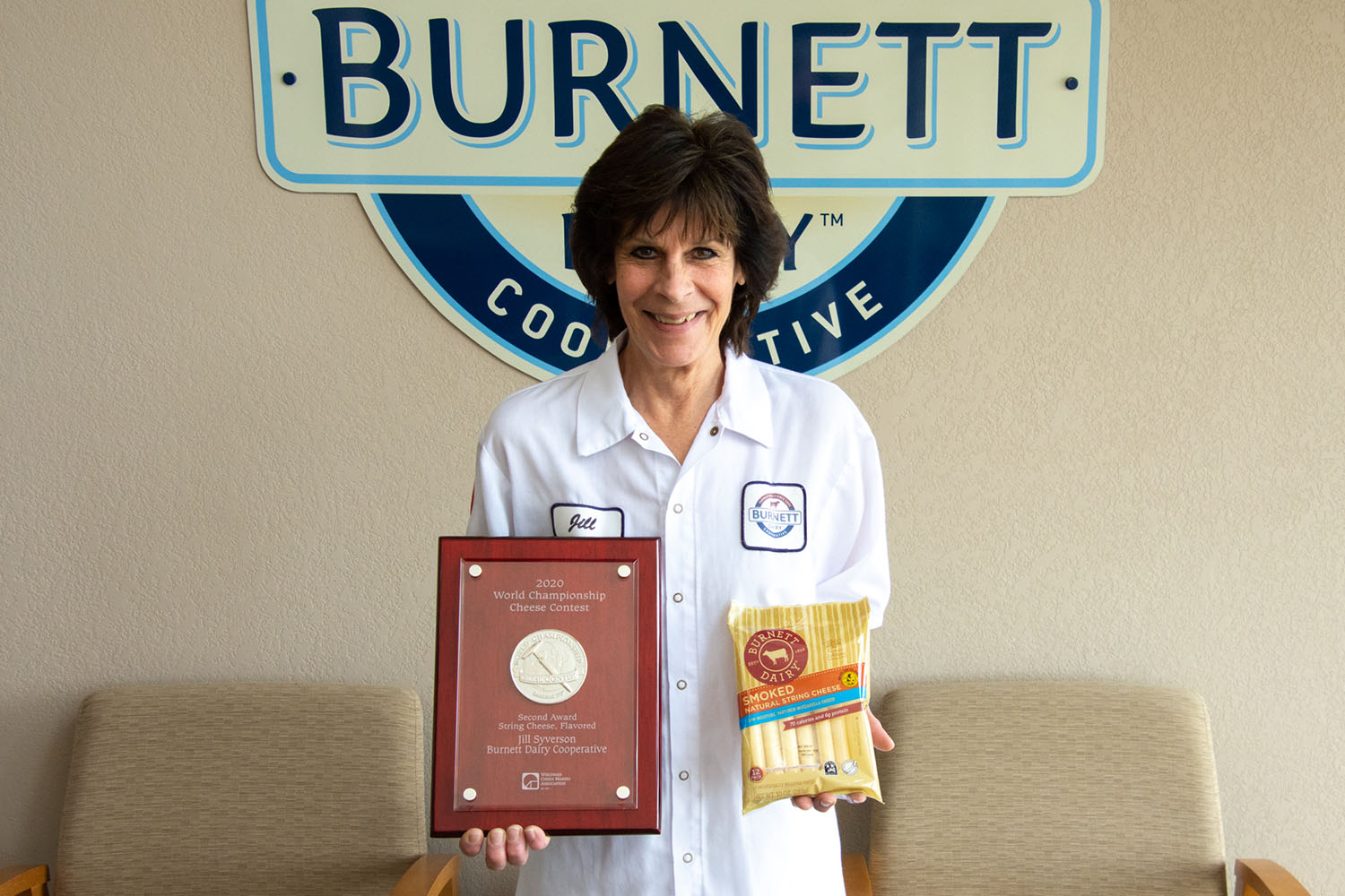 Jill-Syverson is the World Champion in the Cheese Contest of 2020-2; Jill is pictured holding her winning packaged cheese and award placard.